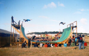 Big airs on a vert skate ramp at a festival.